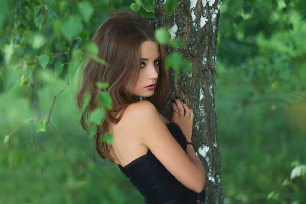 Chica en el bosque entre los árboles verdes