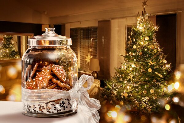 Prepararsi per Natale e Capodanno. Abete decorato e un regalo a forma di barattolo di biscotti allo zenzero