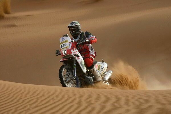 Coureur de moto parmi les dunes de sable