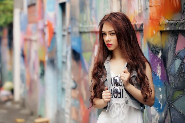 Long-haired girl at the graffiti wall