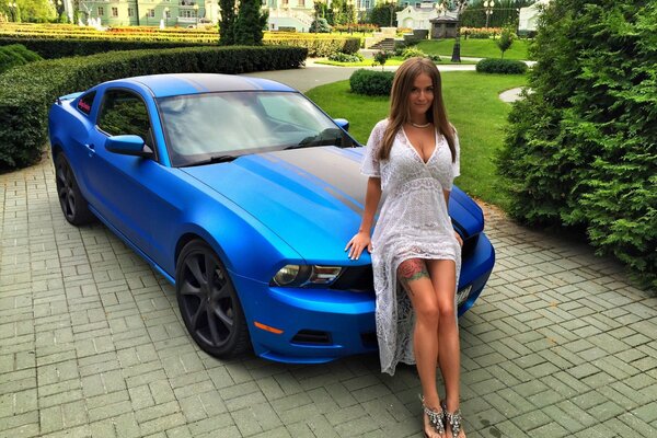 Schönes Mädchen auf einem blauen Ford Mustang Hintergrund