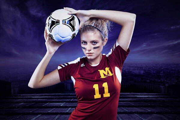 Ragazza in uniforme da calcio con la palla