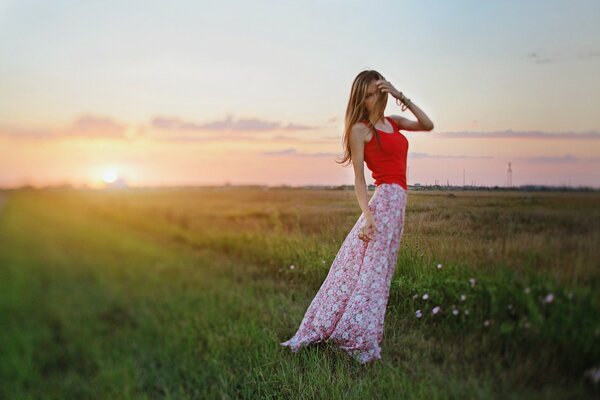 Ragazza in gonna lunga sullo sfondo del tramonto