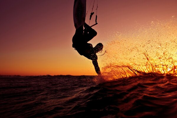 Surfer on a wave in the sunset