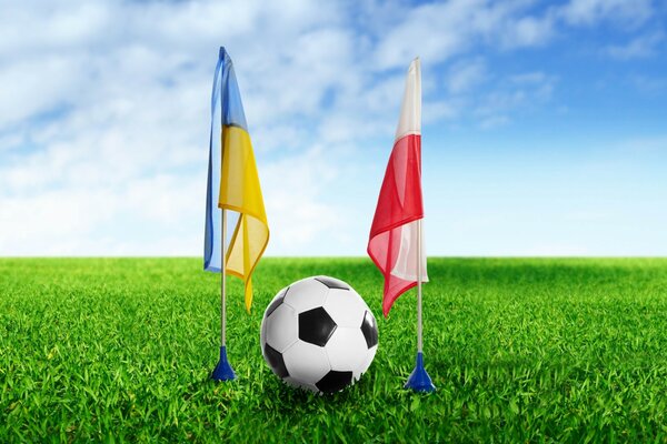 Pallone da calcio tra le bandiere Dell Ucraina e della Polonia