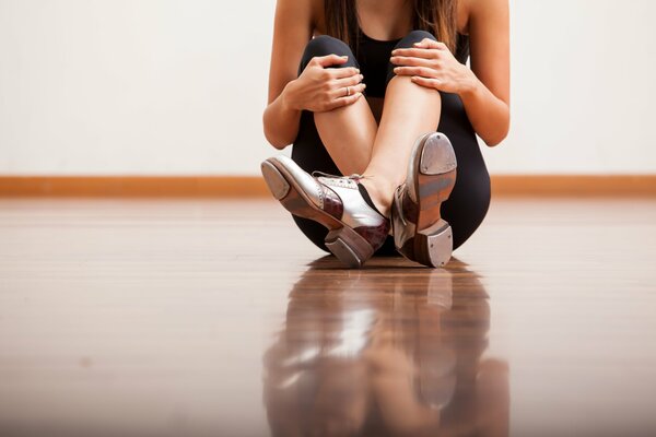 Ragazza seduta sul pavimento, prendendo una pausa dalla danza