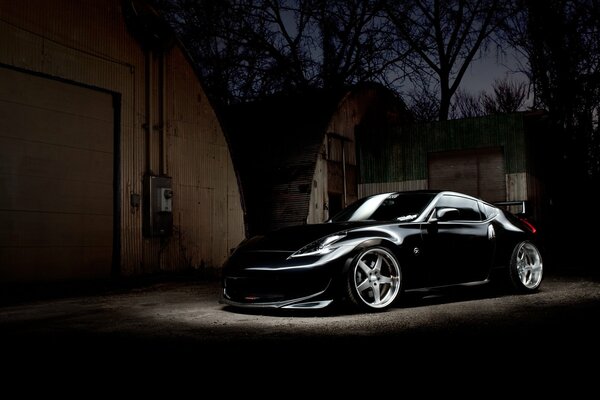 A shiny black Nissan is parked