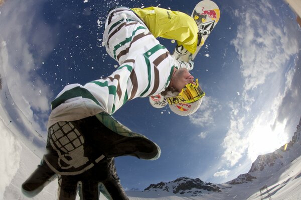 Сноубордист в прыжке среди снега и неба