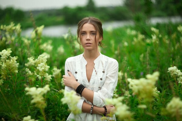 Una joven en un campo de verano floreciente