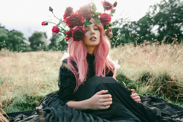 Fille dans un champ avec des roses sur la tête