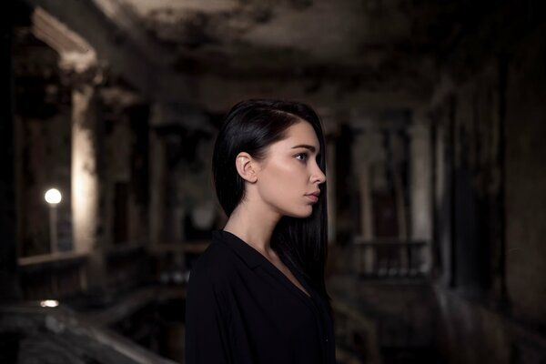 A girl with black hair stands in profile