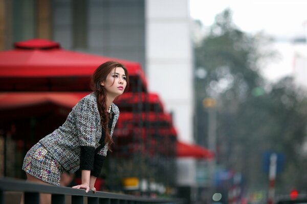 In the camera lens, an Asian woman on the street