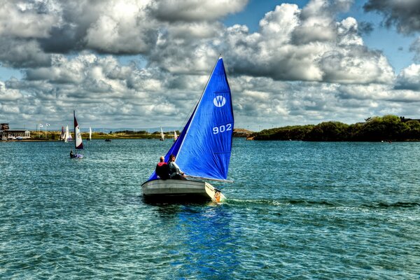 Segelboote in blauem Willen auf bewölktem Himmel Hintergrund