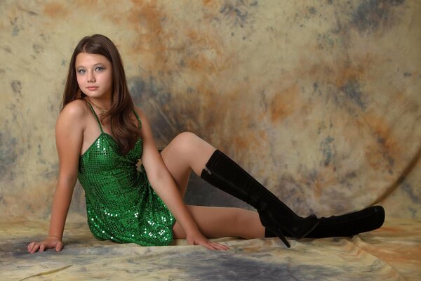 A long-haired girl in a green dress and black boots