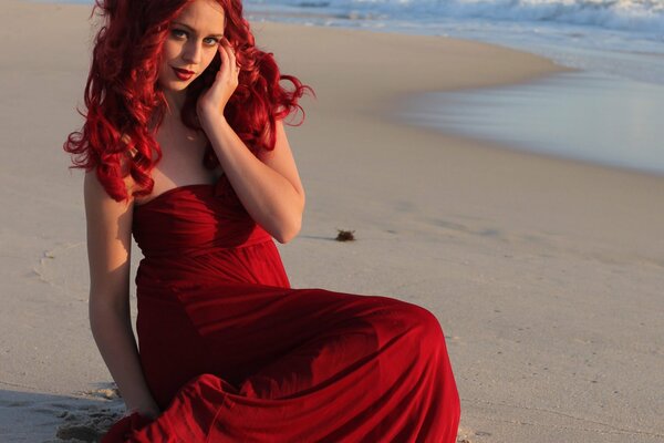 Fille en robe rouge sur le sable