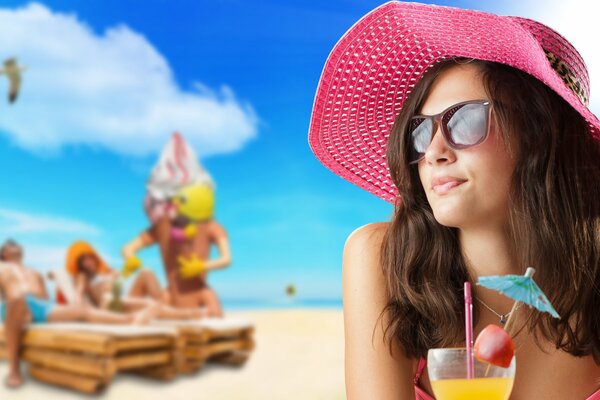 A girl with brown hair in sunglasses drinks a cocktail on the beach