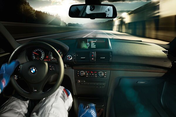 The hands of a racer lying on the steering wheel and lever in a bmw car racing along the track