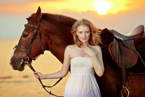 Giovane ragazza con il cavallo sulla riva