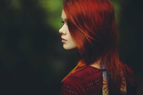 Rousse-fille aux cheveux regarde au loin