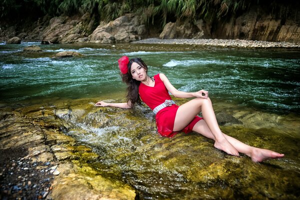 Ragazza asiatica aspetto sulla riva del fiume