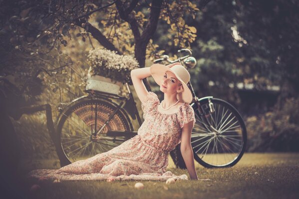 Ragazza in un cappello fotografata con una bicicletta