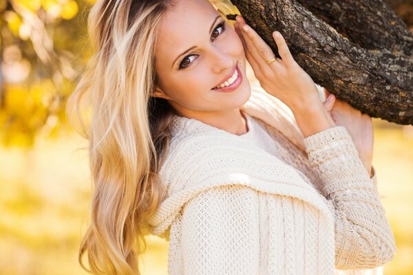 A girl in a white blouse near a tree