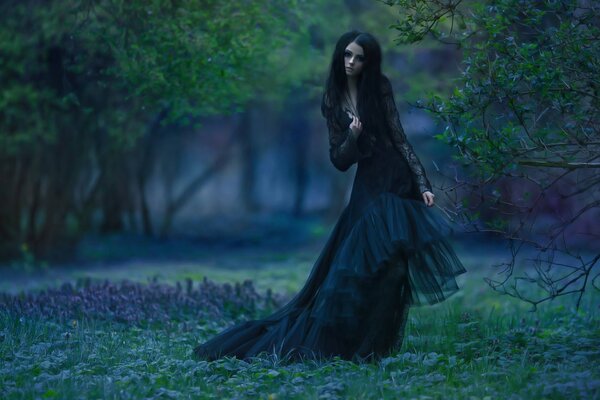 Morena en vestido negro en el parque