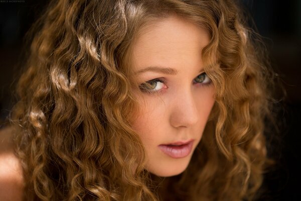 Fille avec un beau regard et des boucles sur les cheveux