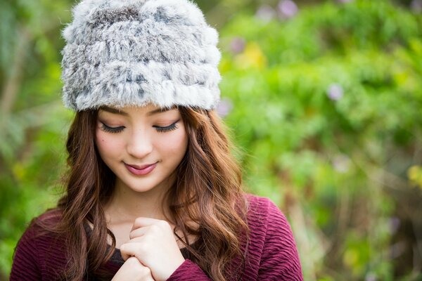 Chica asiática en un gorro en el parque