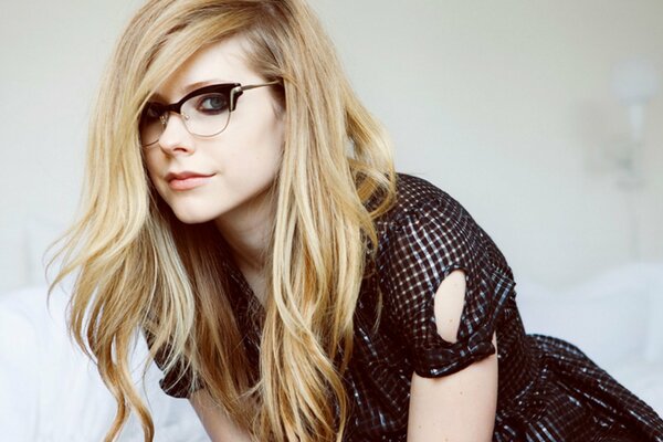 Avril Lavigne con gafas se agachó