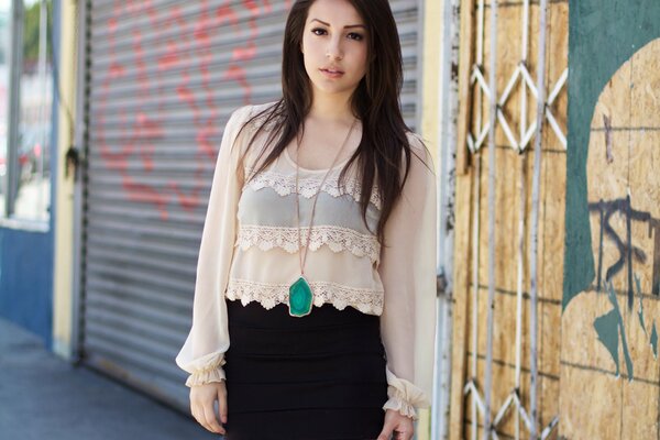 Chica en blusa en la pared de fondo