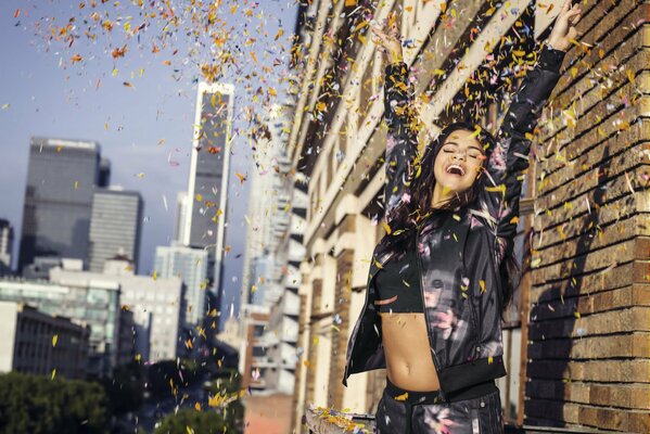 Selena Gomez near the wall with confetti