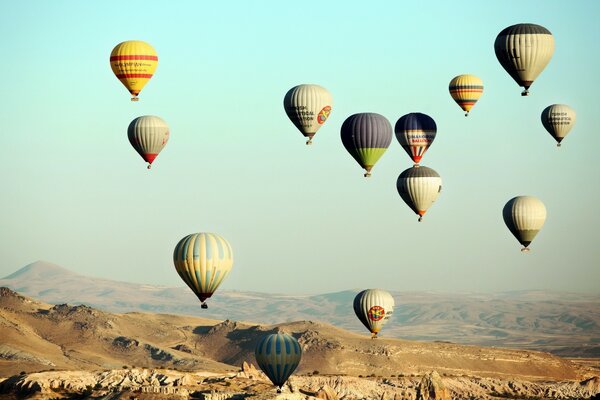 Viele Ballons fliegen in den Himmel über den Hügeln