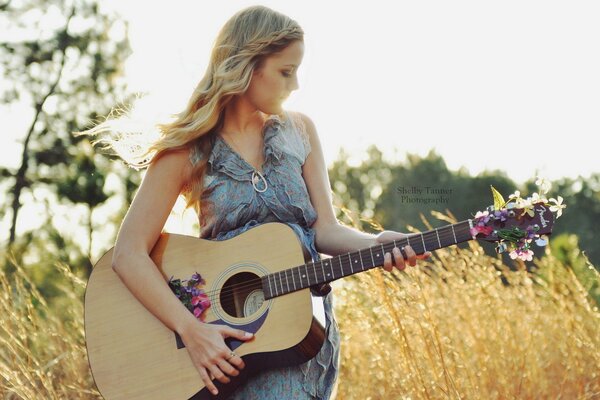 Chica delgada con guitarra en la naturaleza