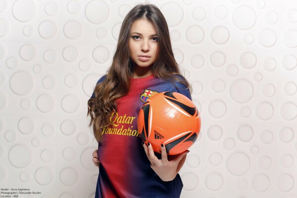 Linda chica en uniforme con una pelota