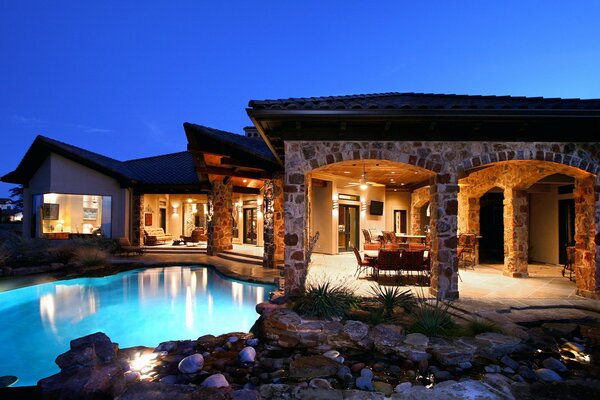 Haus mit Pool im Stil aus Stein. Im Inneren des Fernsehers