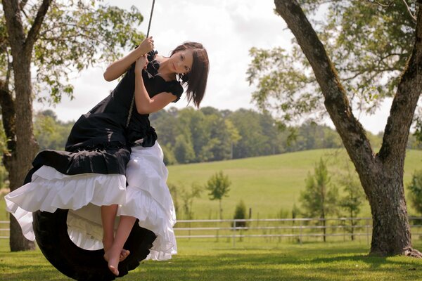 A girl swings on a homemade swing