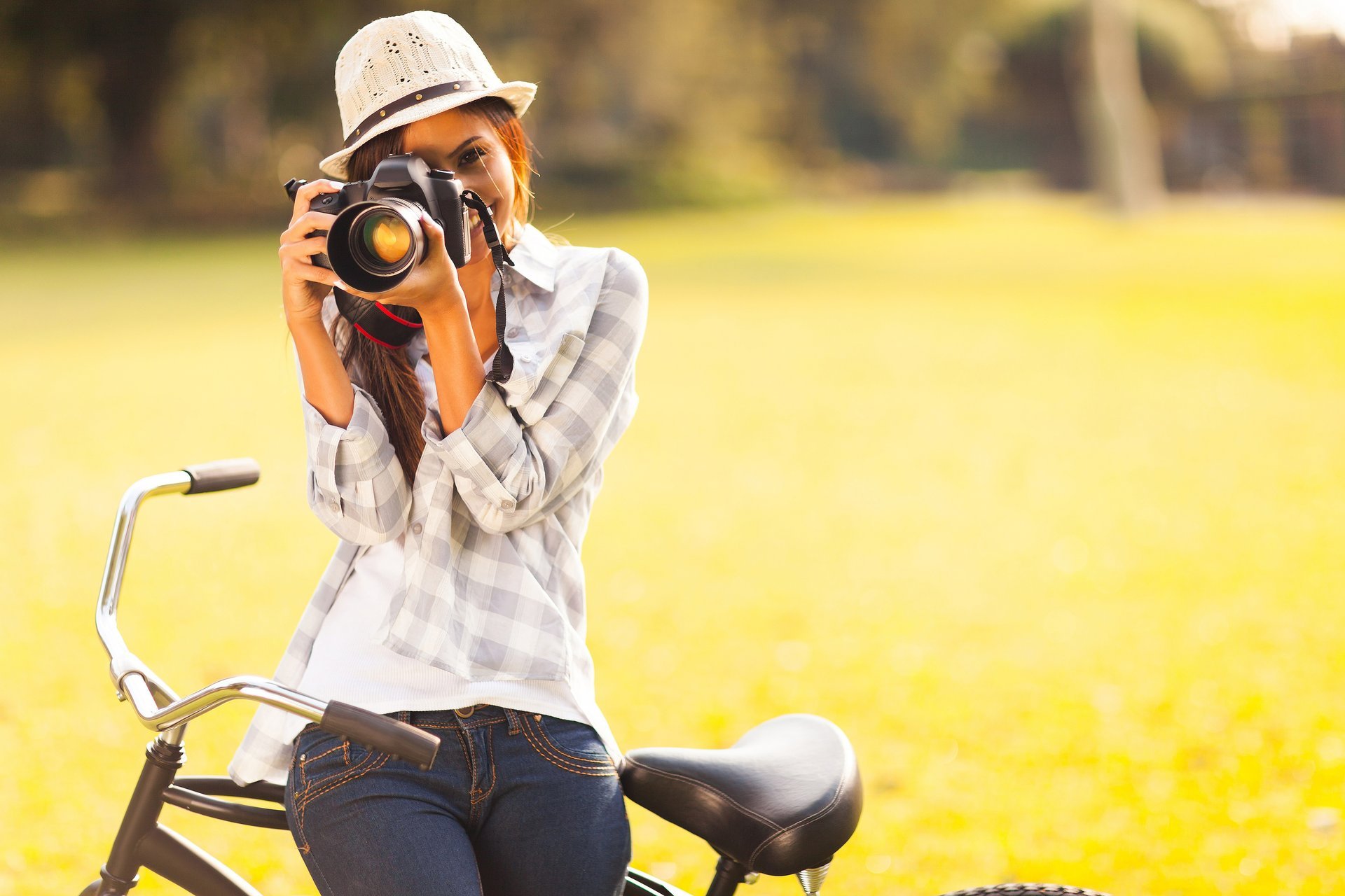 fille brune chapeau appareil photo vélo sourire verdure