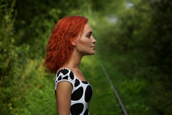 Retrato de una niña con el pelo rojo sobre un fondo verde