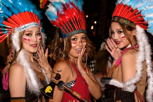 Trois filles souriantes et posant avec des plumes sur la tête