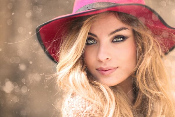 Fille blonde avec un chapeau rose sur la tête