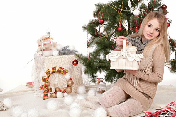 Chica cerca del árbol de Navidad con regalos