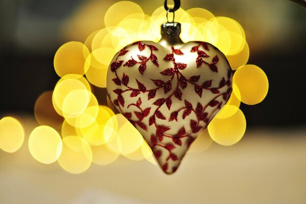 New Year s toy in the shape of a heart with an ornament of leaves