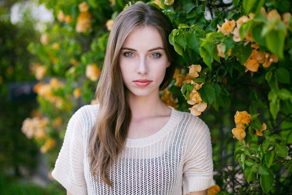 Portrait photo du modèle Megan Coffey sur fond de fleurs