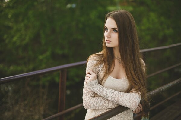 Fille sur le pont en robe de dentelle