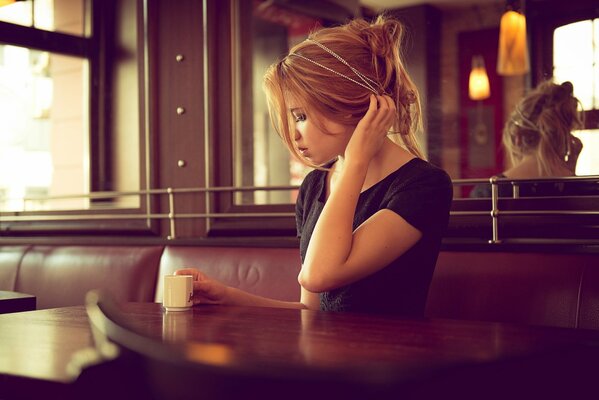 Fille dans un café avec une tasse de café