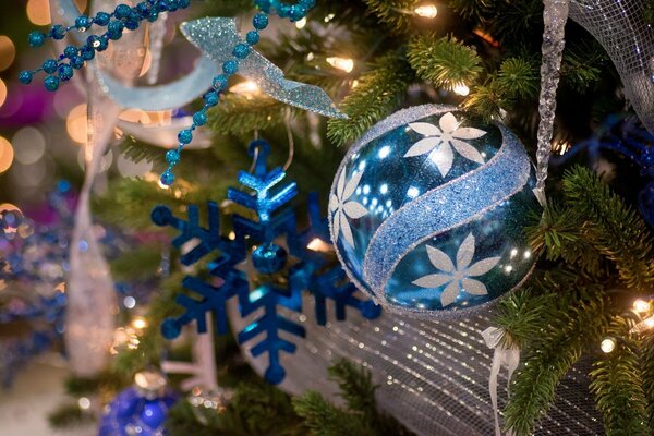 Eine blaue Christbaumkugel und eine blaue Schneeflocke am Weihnachtsbaum