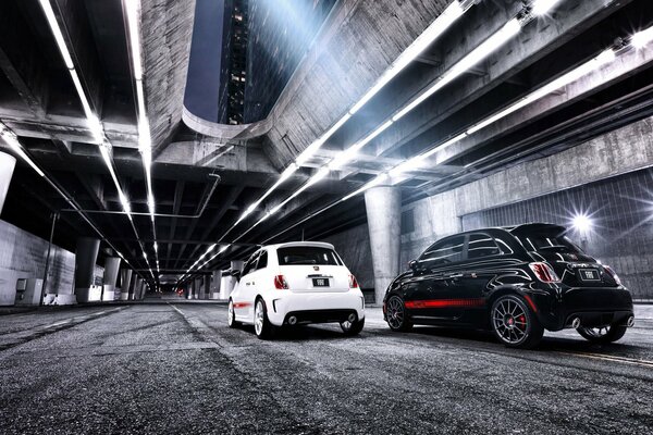 Black and white cars are driving along the road in the tunnel