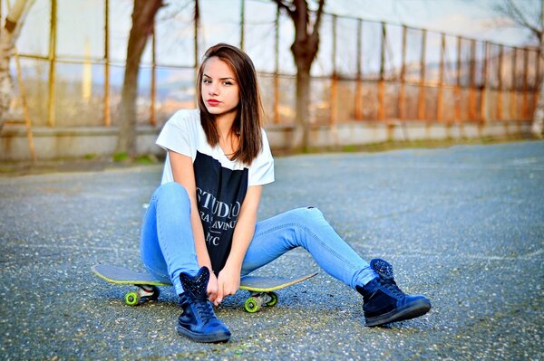 Una ragazza in Bulgaria si siede su uno skateboard