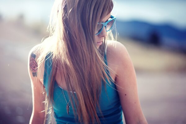 A girl in a blue swimsuit with glasses